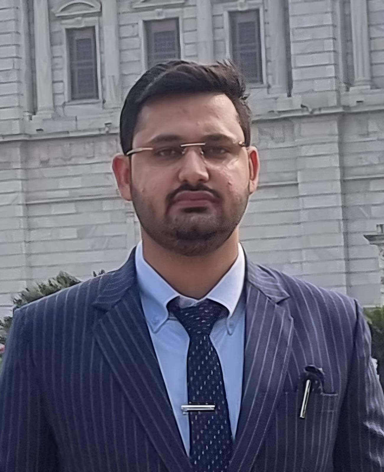 Portrait of Rahul Bhardwaj in a navy pinstripe suit